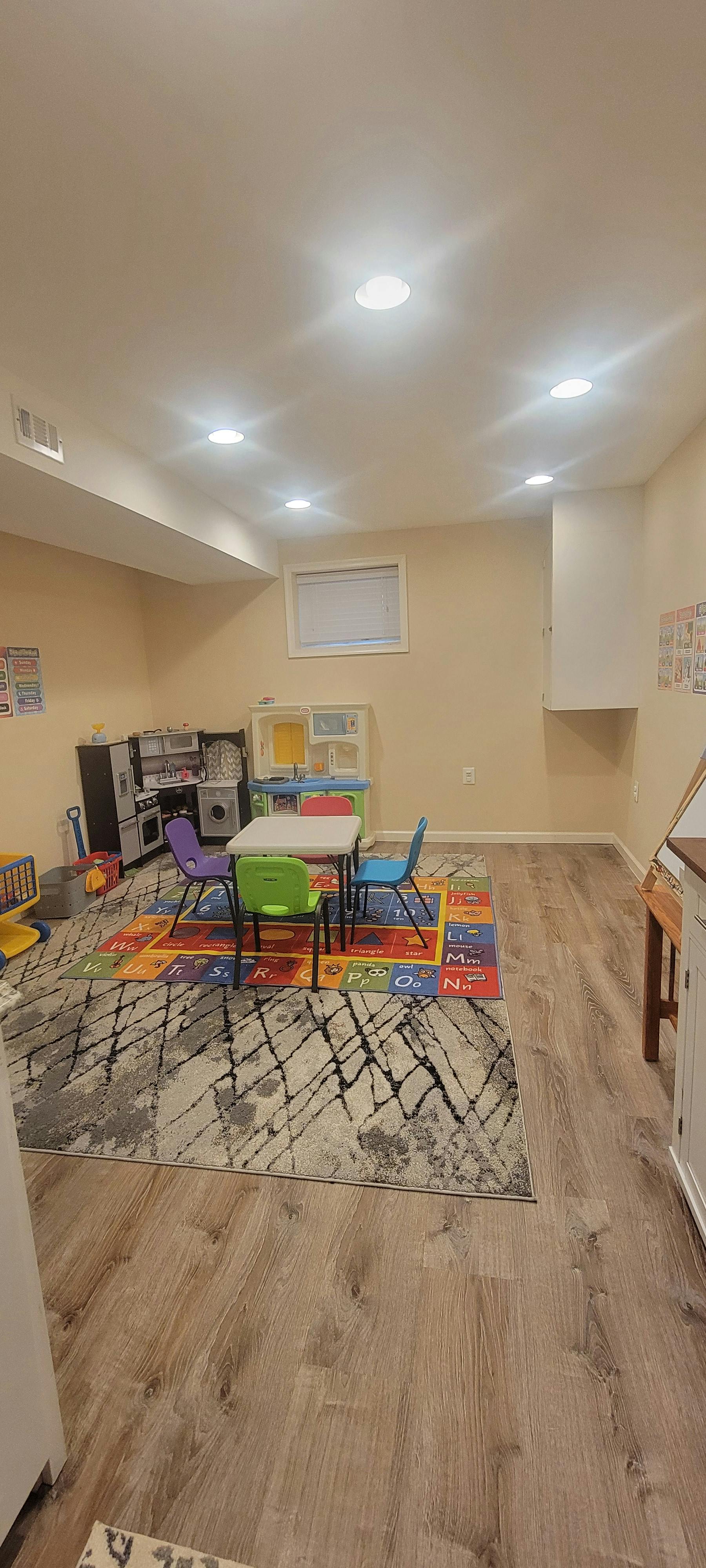 Small table and chairs on a colorful alphabet rug in a playroom
