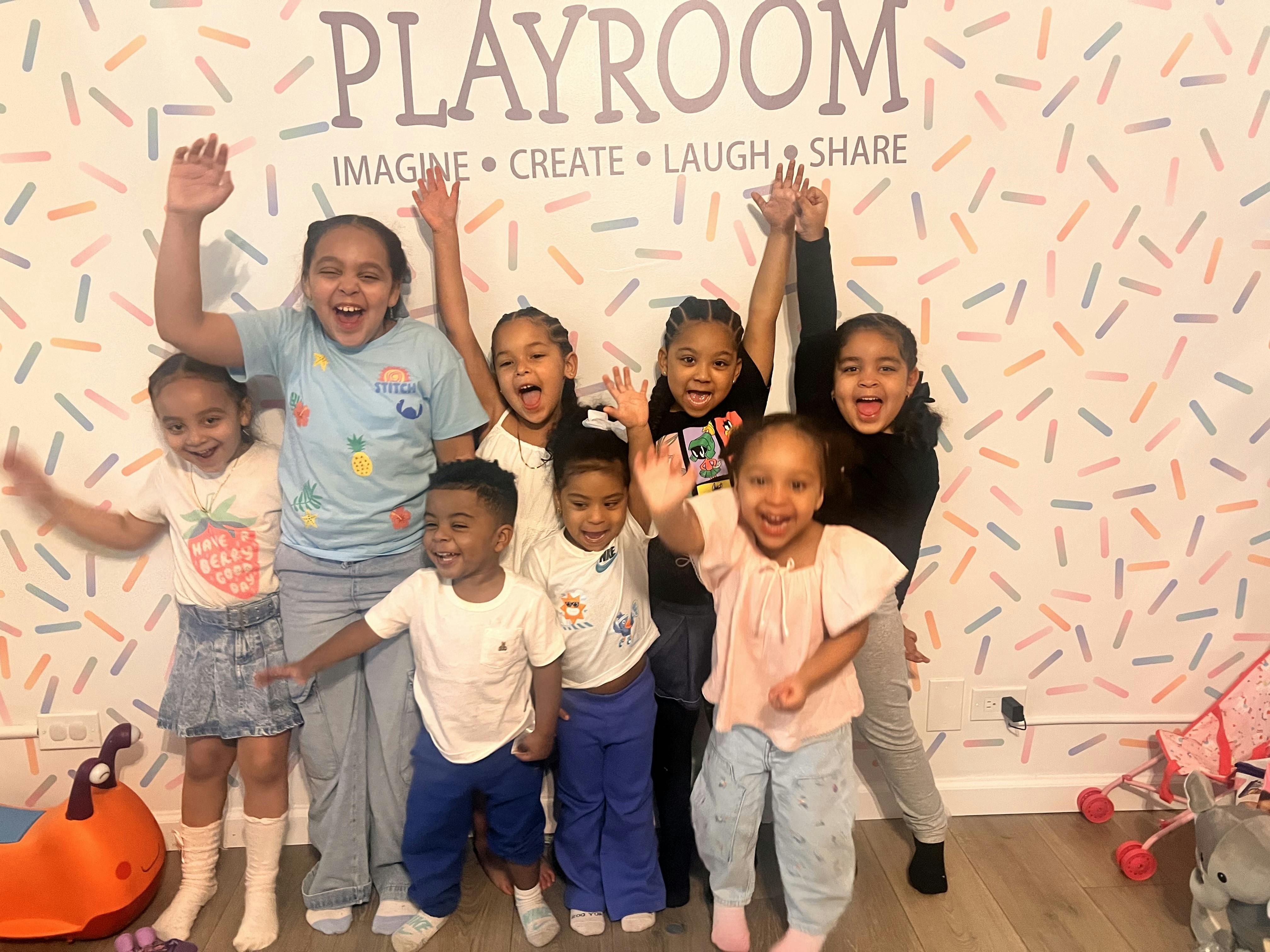 Group of children waving in a playroom