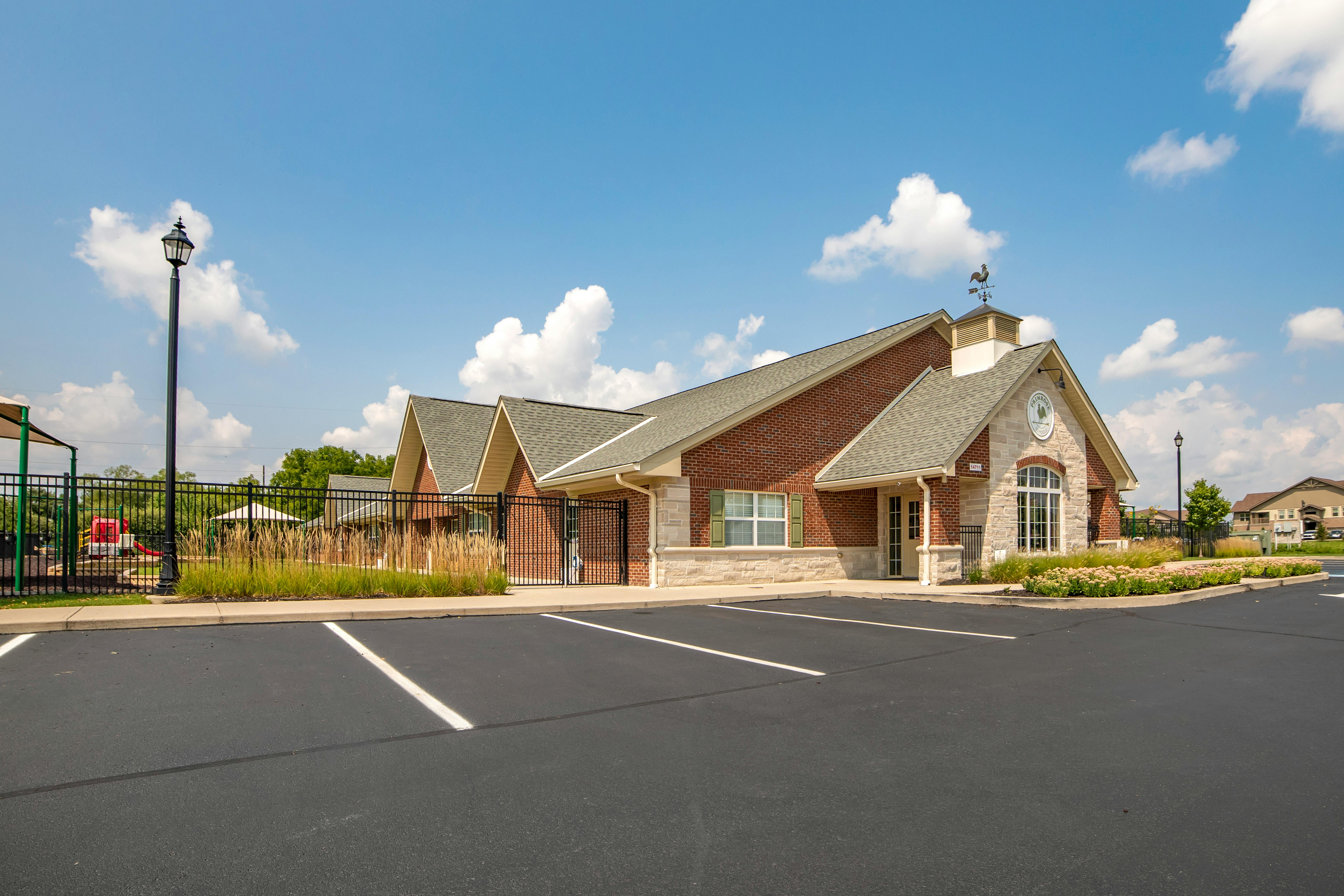 Brick building with a playground and empty parking lot