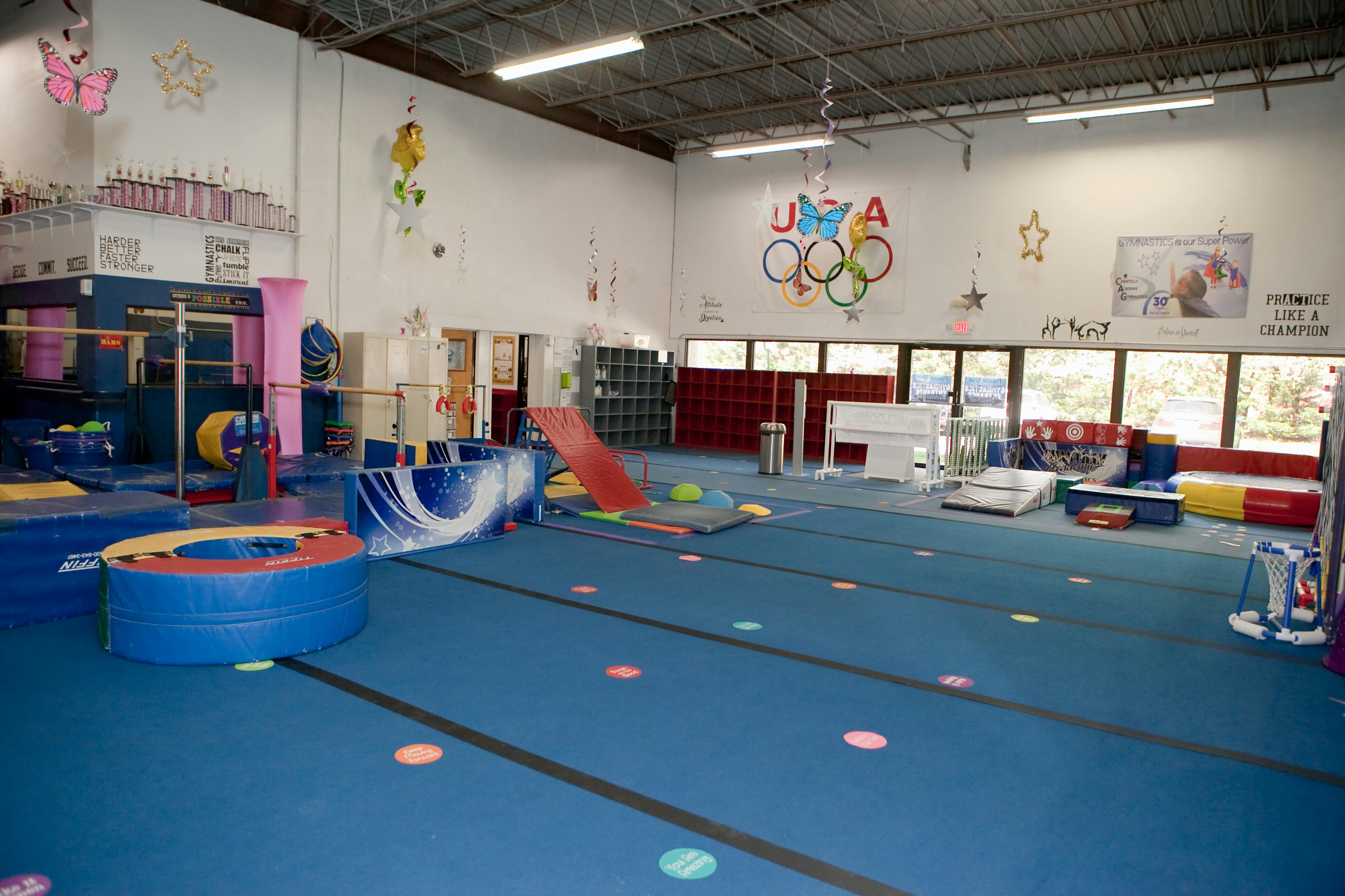 Gymnastics facility with blue floor mats and various equipment