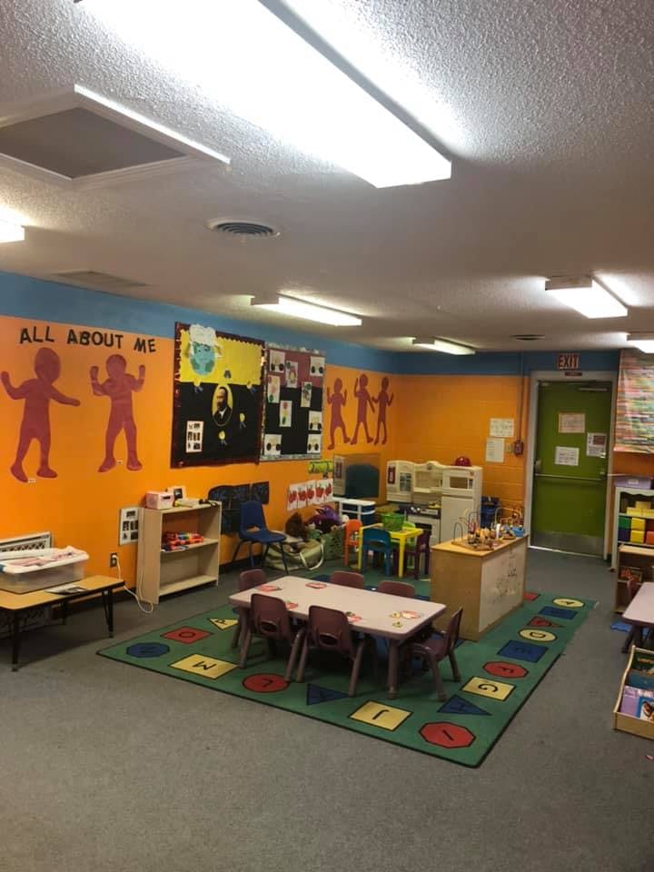 Classroom with tables, chairs, and colorful decorations on the walls