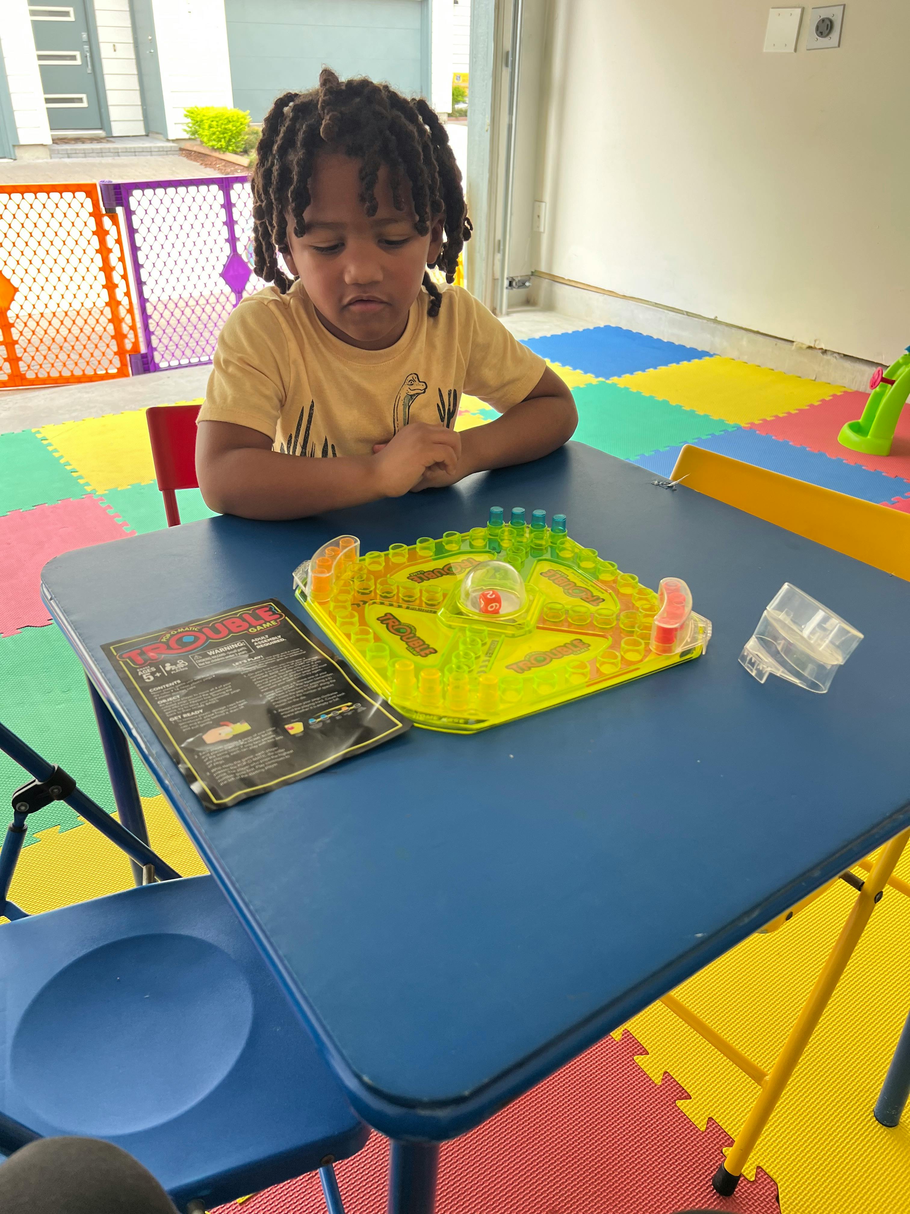 Child sitting at a table with a board game