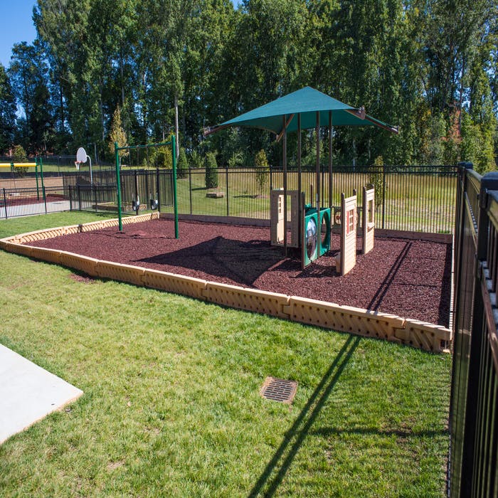 Playground with wood chip ground cover and green play structure