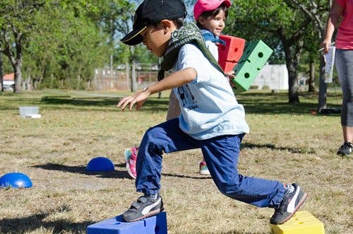 Child stepping on blocks outdoors