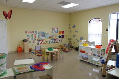 Empty classroom with small tables and chairs, decorated walls