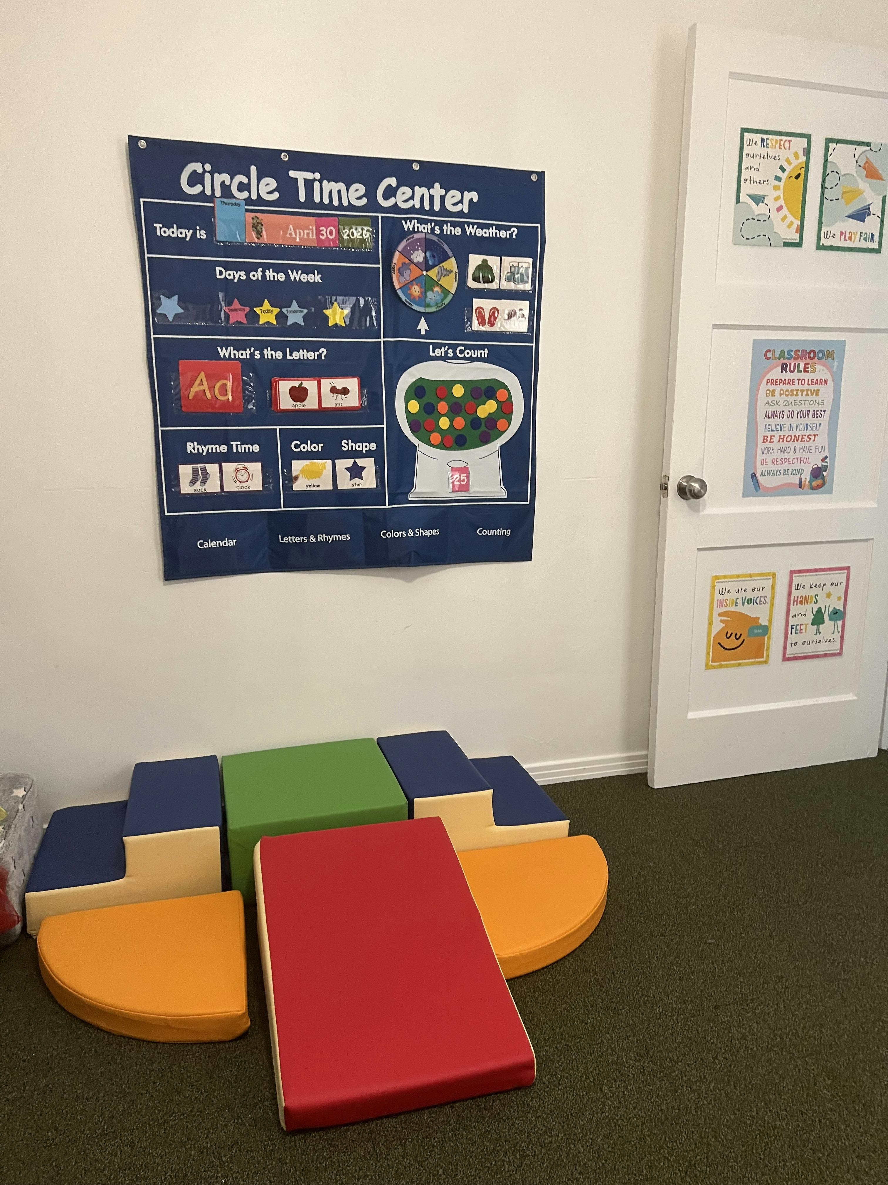 Classroom wall with an educational circle time calendar and soft play mats