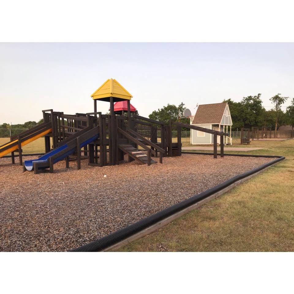 Playground with slides, climbing structures, and a small playhouse