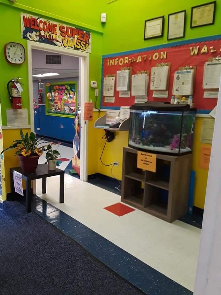 Classroom entrance with a welcome sign, information board, and fish tank