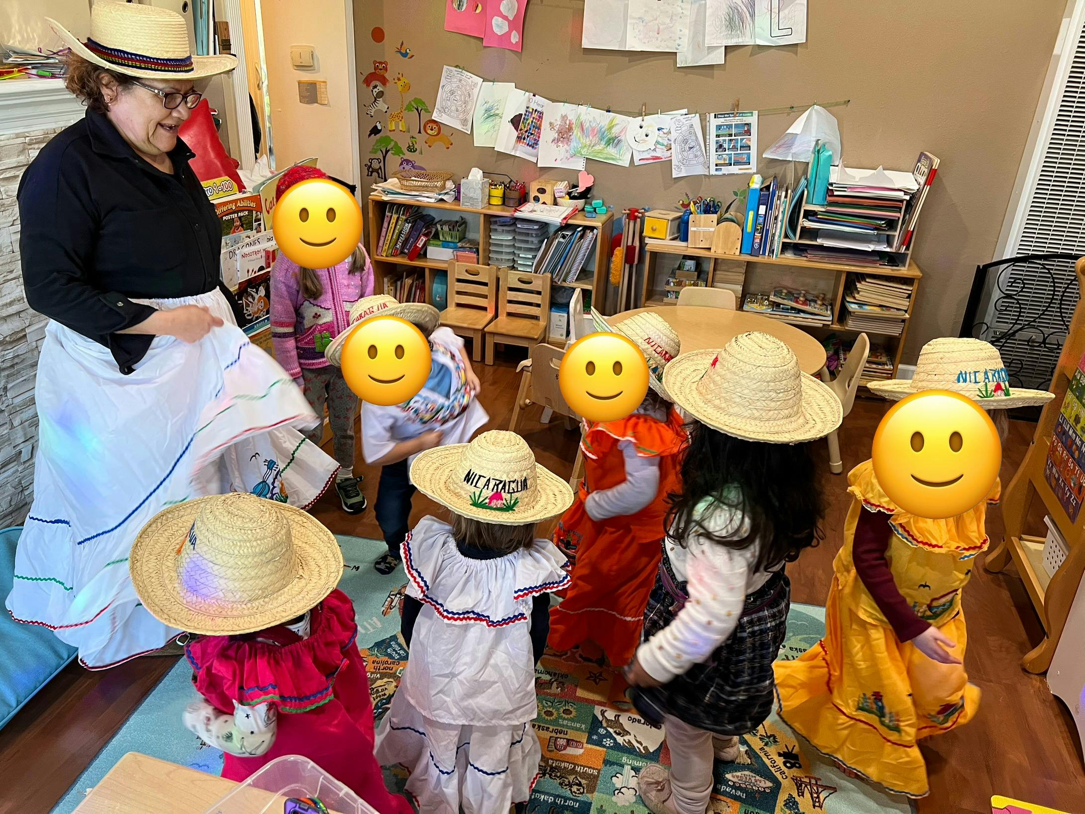 Adult and children wearing straw hats and traditional clothing in a classroom