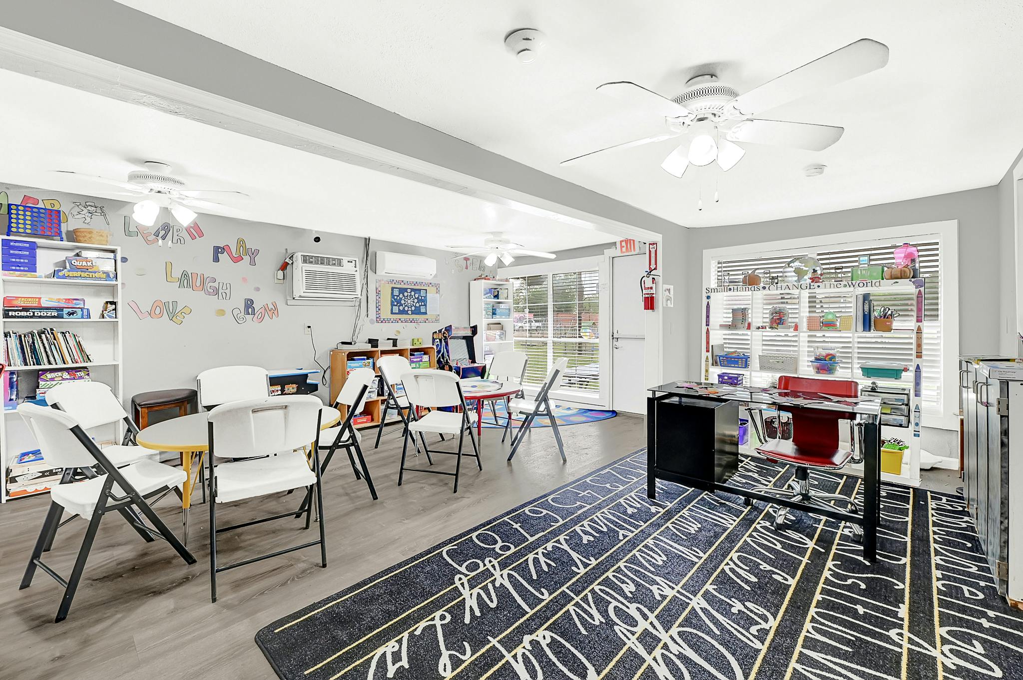 Classroom with white folding chairs and a rug with alphabet letters