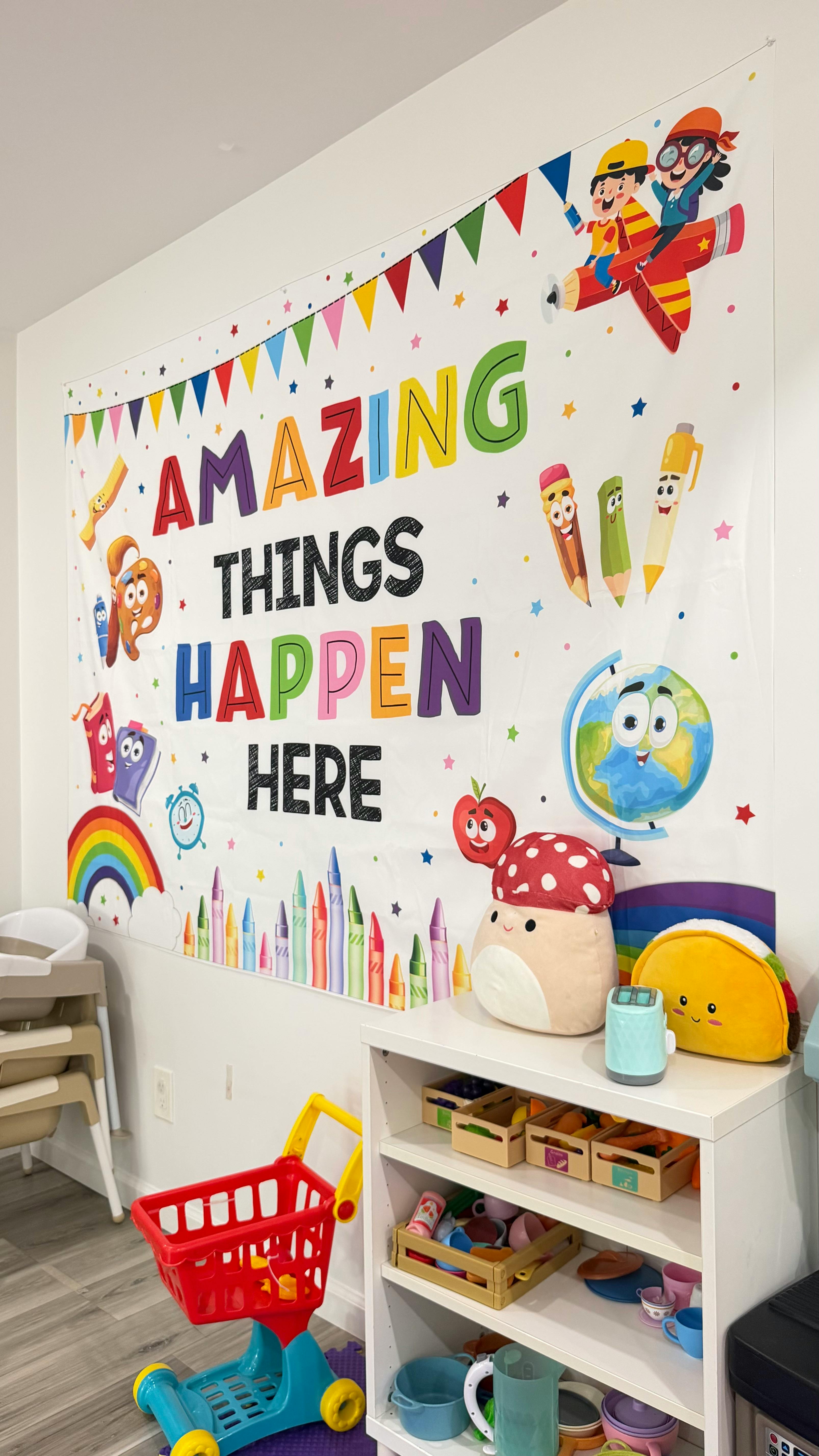 Decorative wall banner with the text Amazing Things Happen Here in a playroom