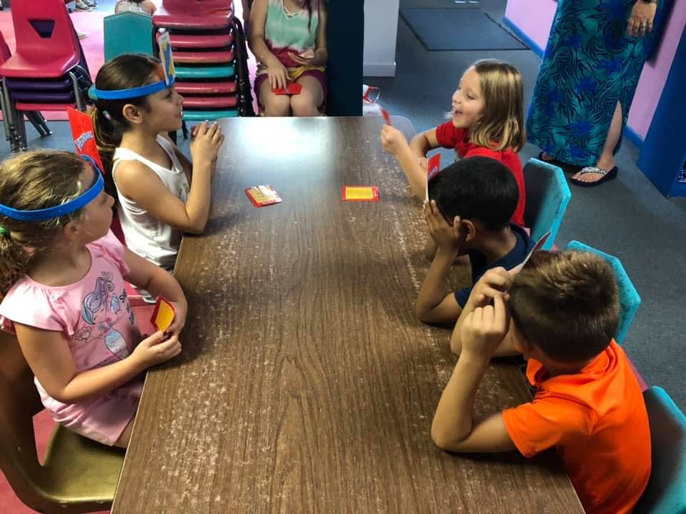 Children sitting at a table playing a game