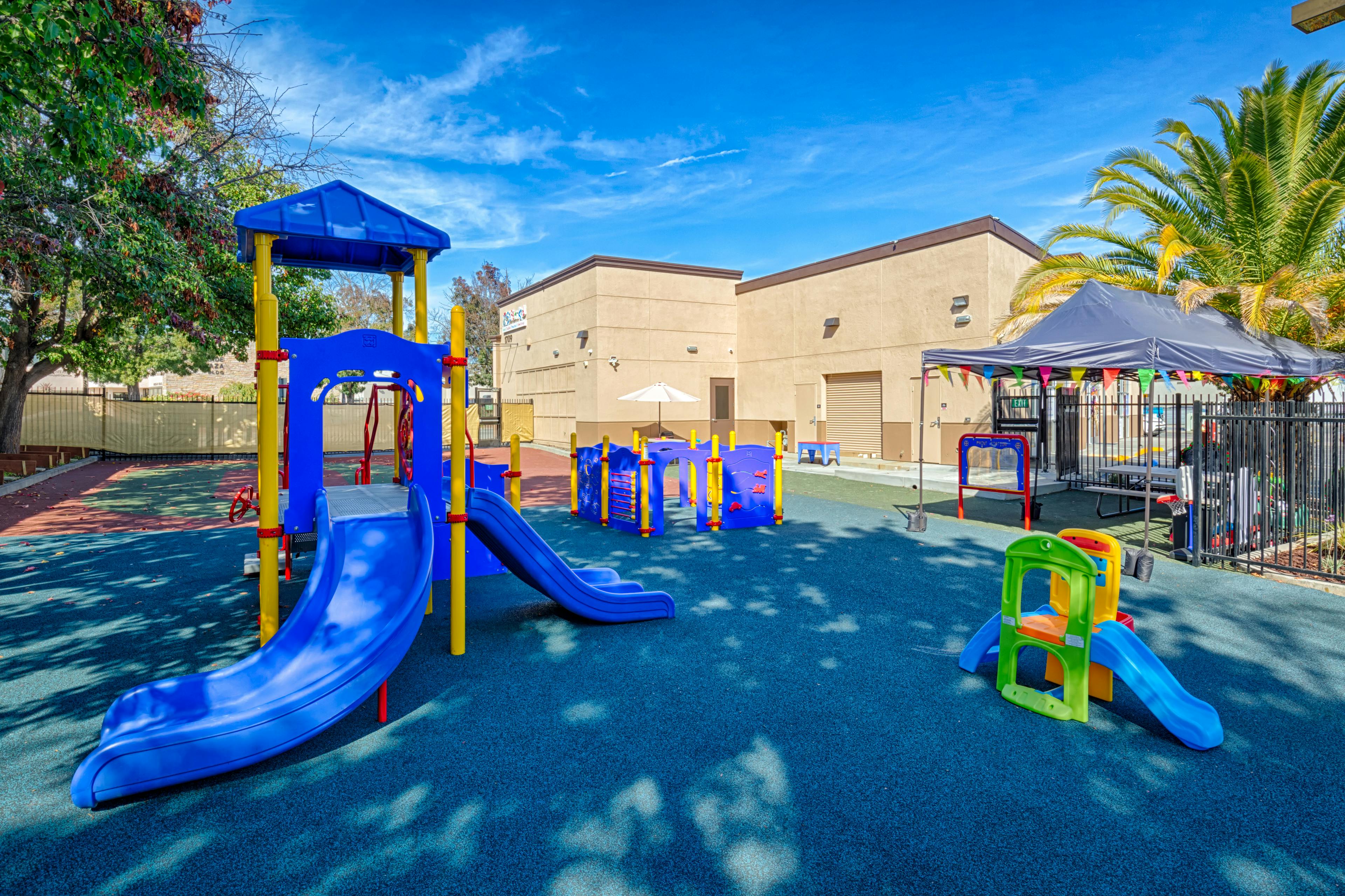 Playground with blue and yellow play structure and slides