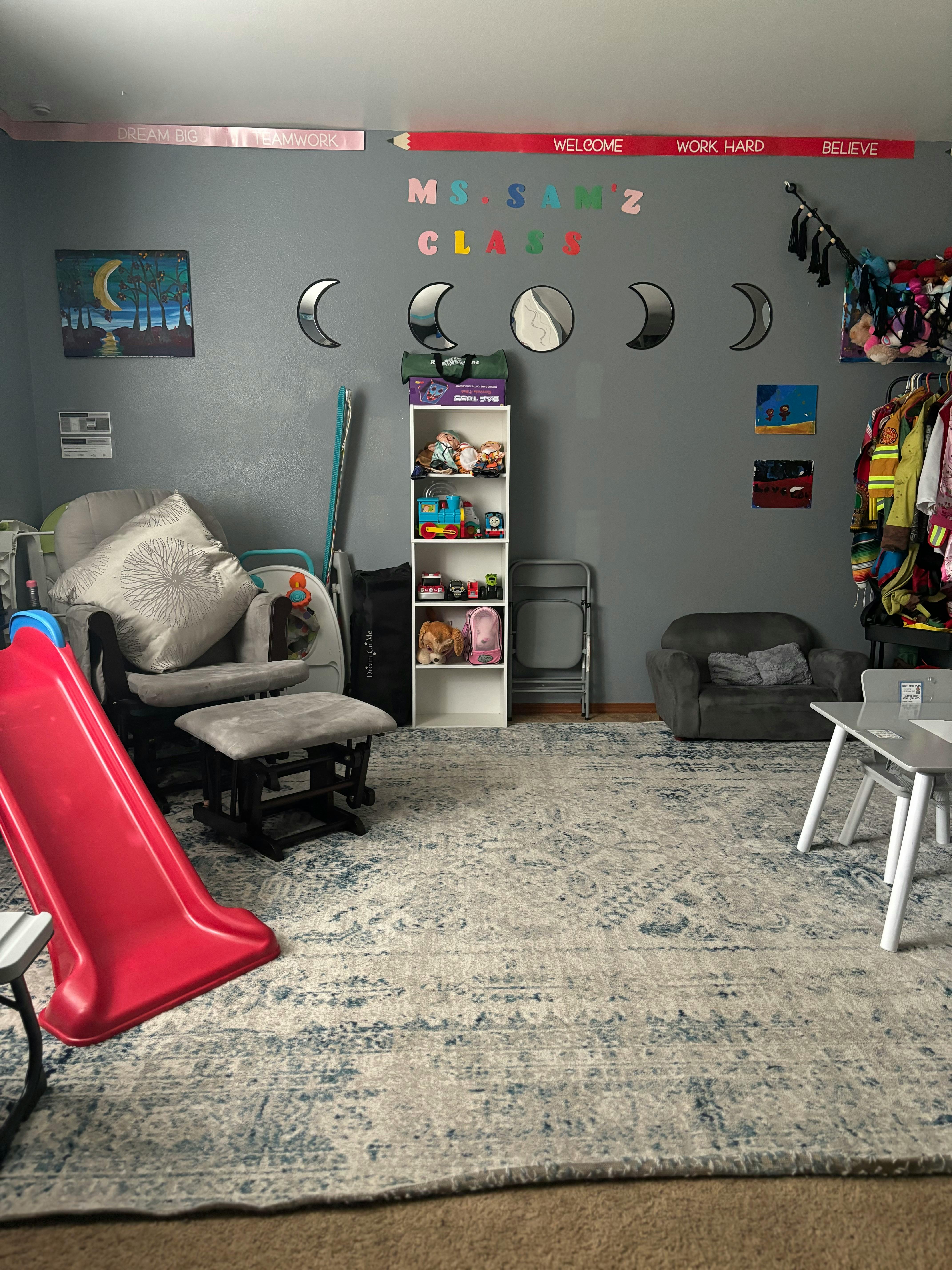 Playroom with a red slide, rocking chair, and toy shelf