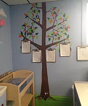 Tree mural on a wall with clipboards hanging from branches