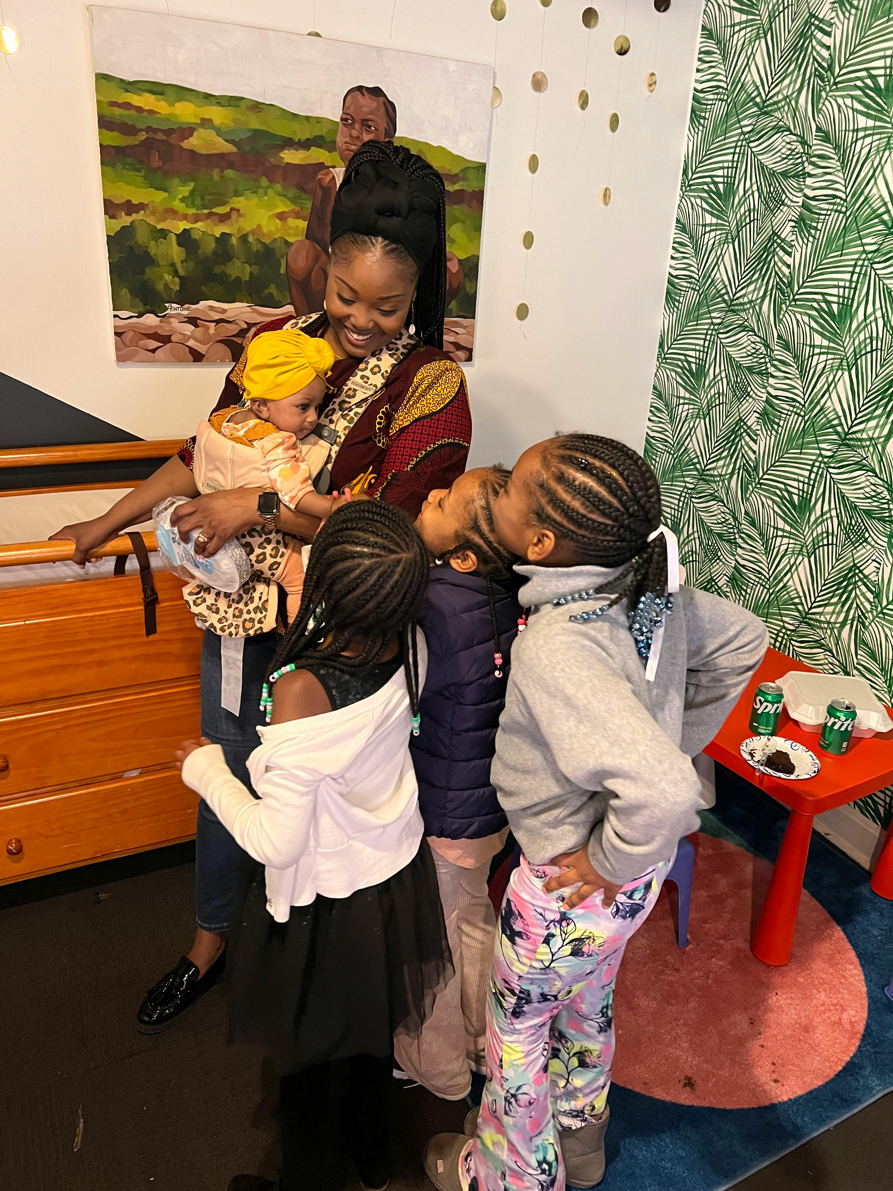 Person holding a baby surrounded by children