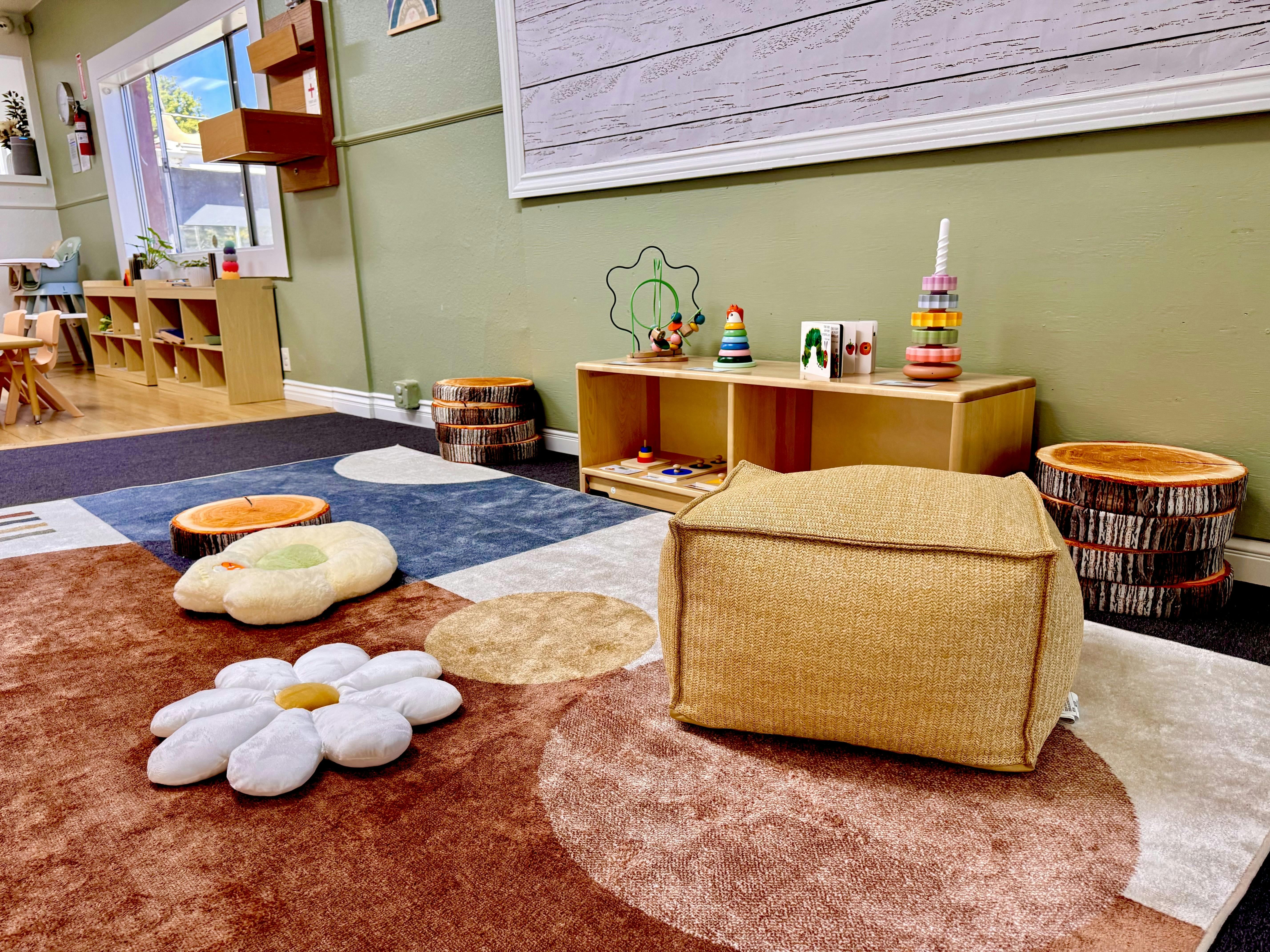 Play area for children with floor cushions and wooden shelving for toys