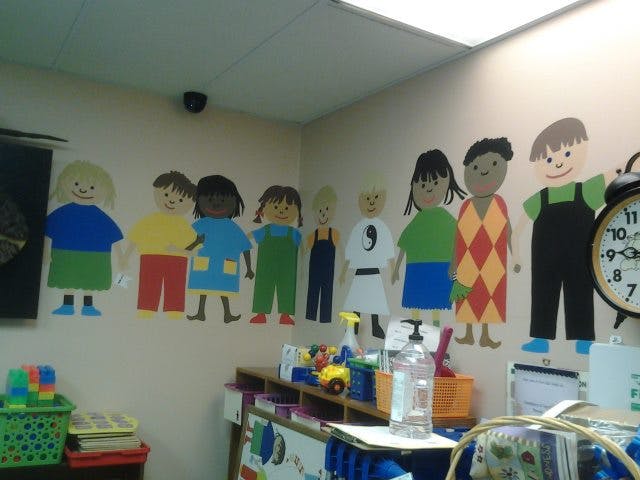 Paper cutouts of children on a wall in a classroom
