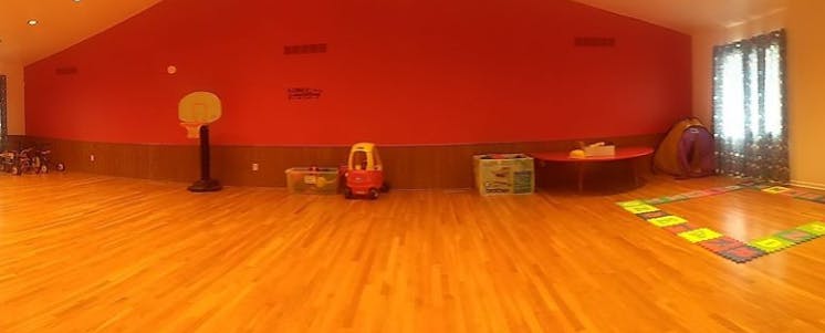 Playroom with hardwood floor, red walls, and various toys