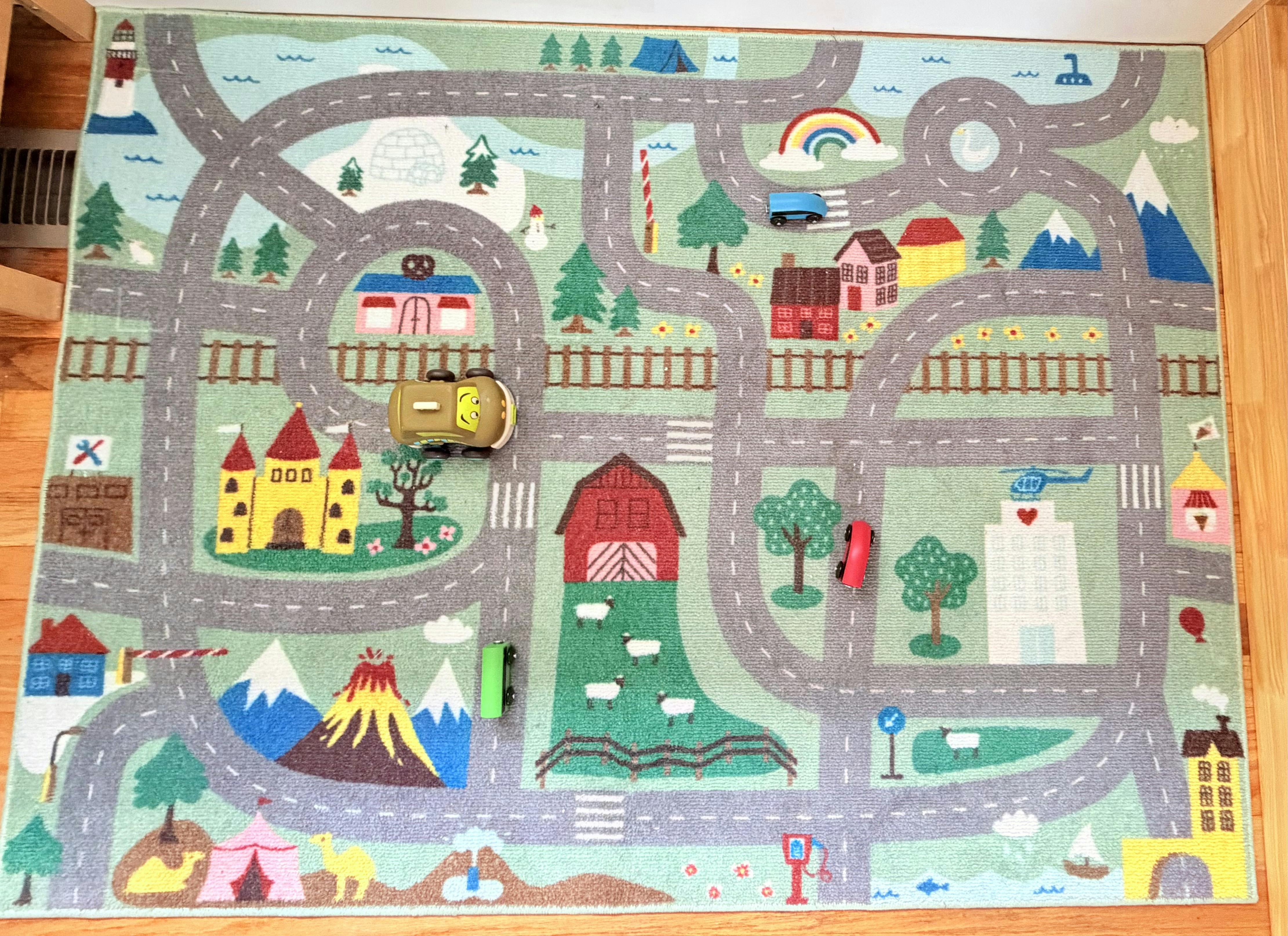 Play mat with roads, buildings, natural scenes, and toy cars
