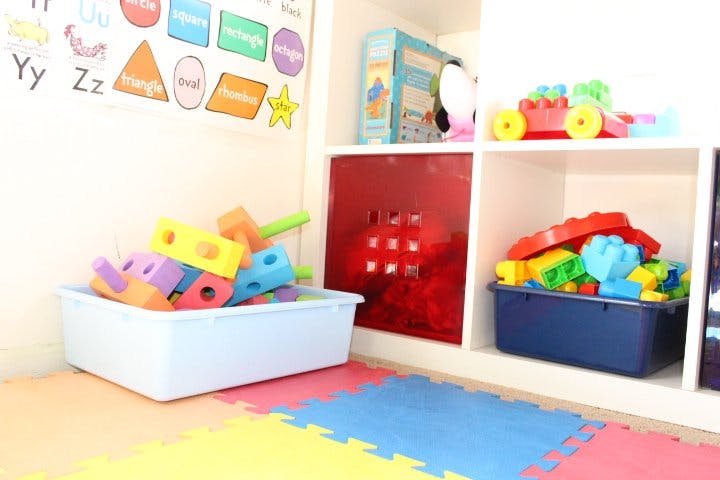Playroom with colorful building blocks in bins and on shelves