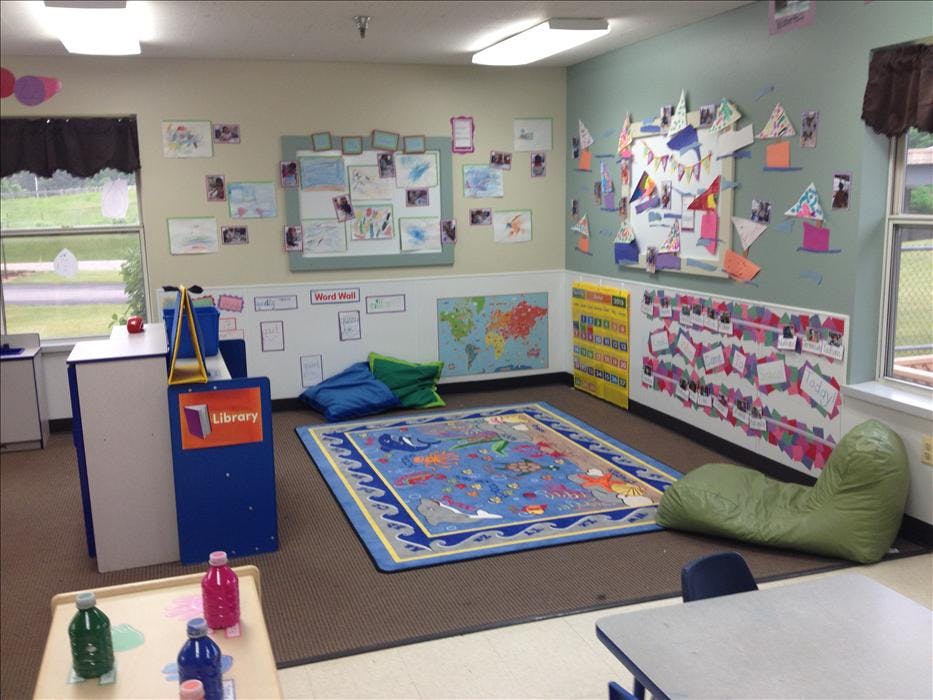 Classroom with a blue rug, beanbag chairs, and student artwork on the walls