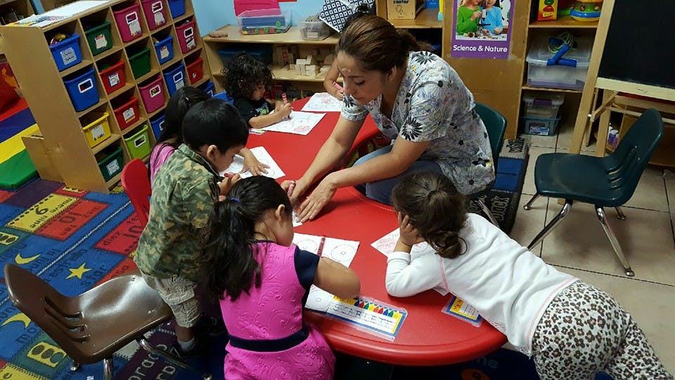Adult and children at a table in a classroom