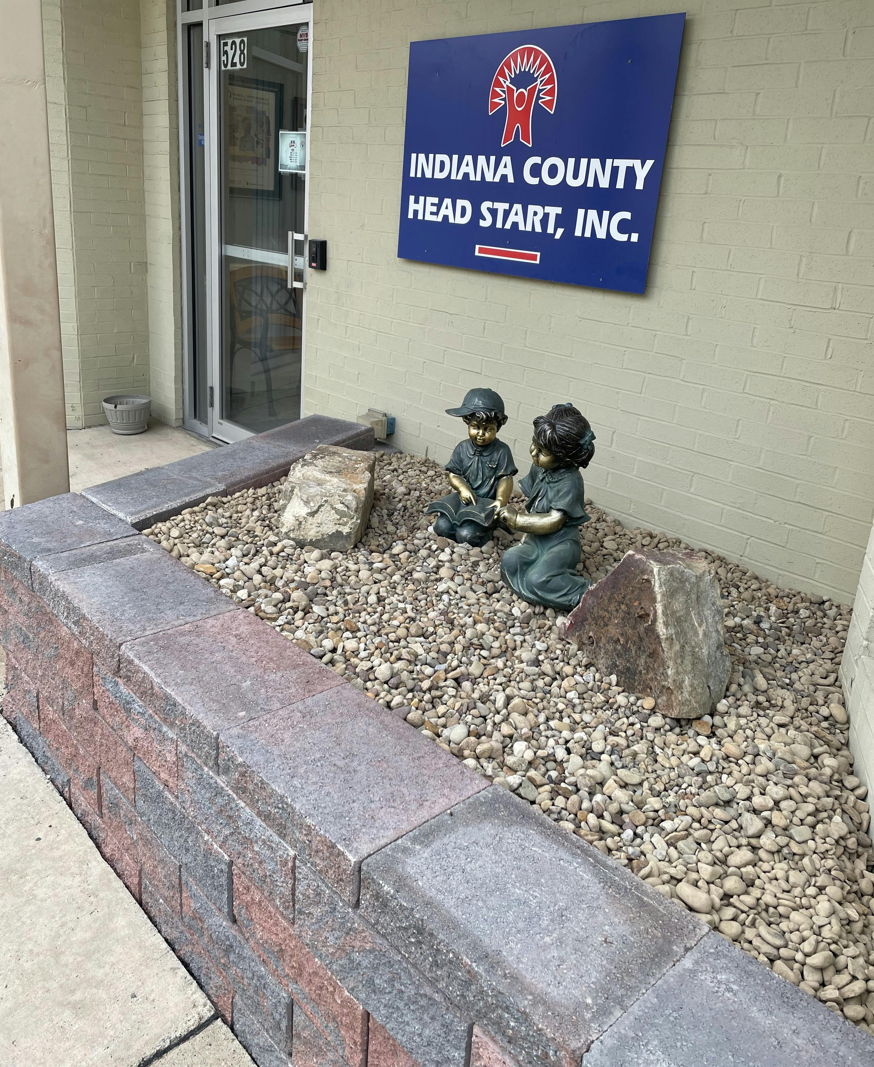 Sign for Indiana County Head Start, Inc. above two child statues