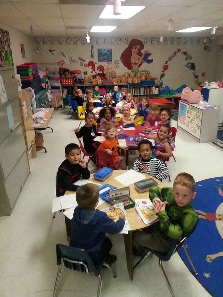 Children sitting at tables in a classroom