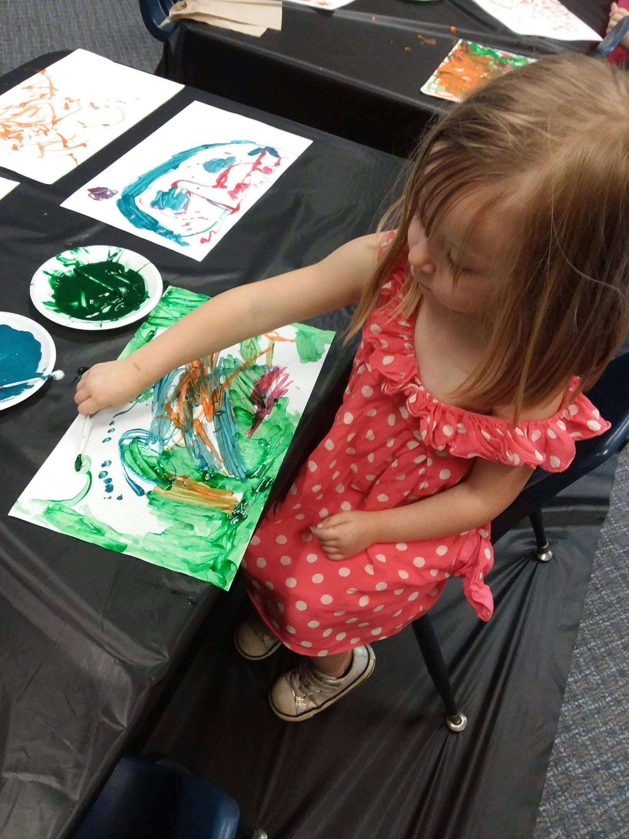 Child painting on paper at a table