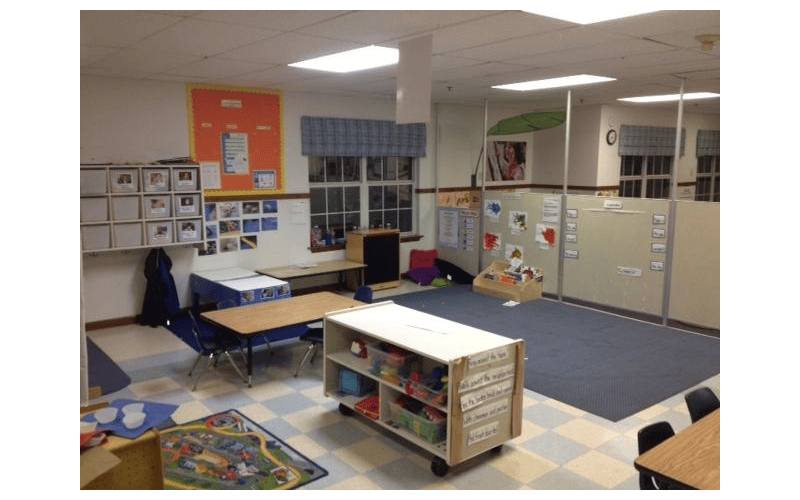Classroom with tables, chairs, learning materials, and room dividers