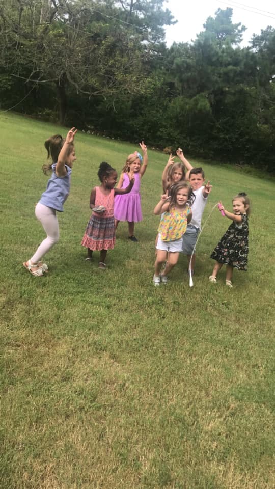Group of children playing outdoors on a grassy field