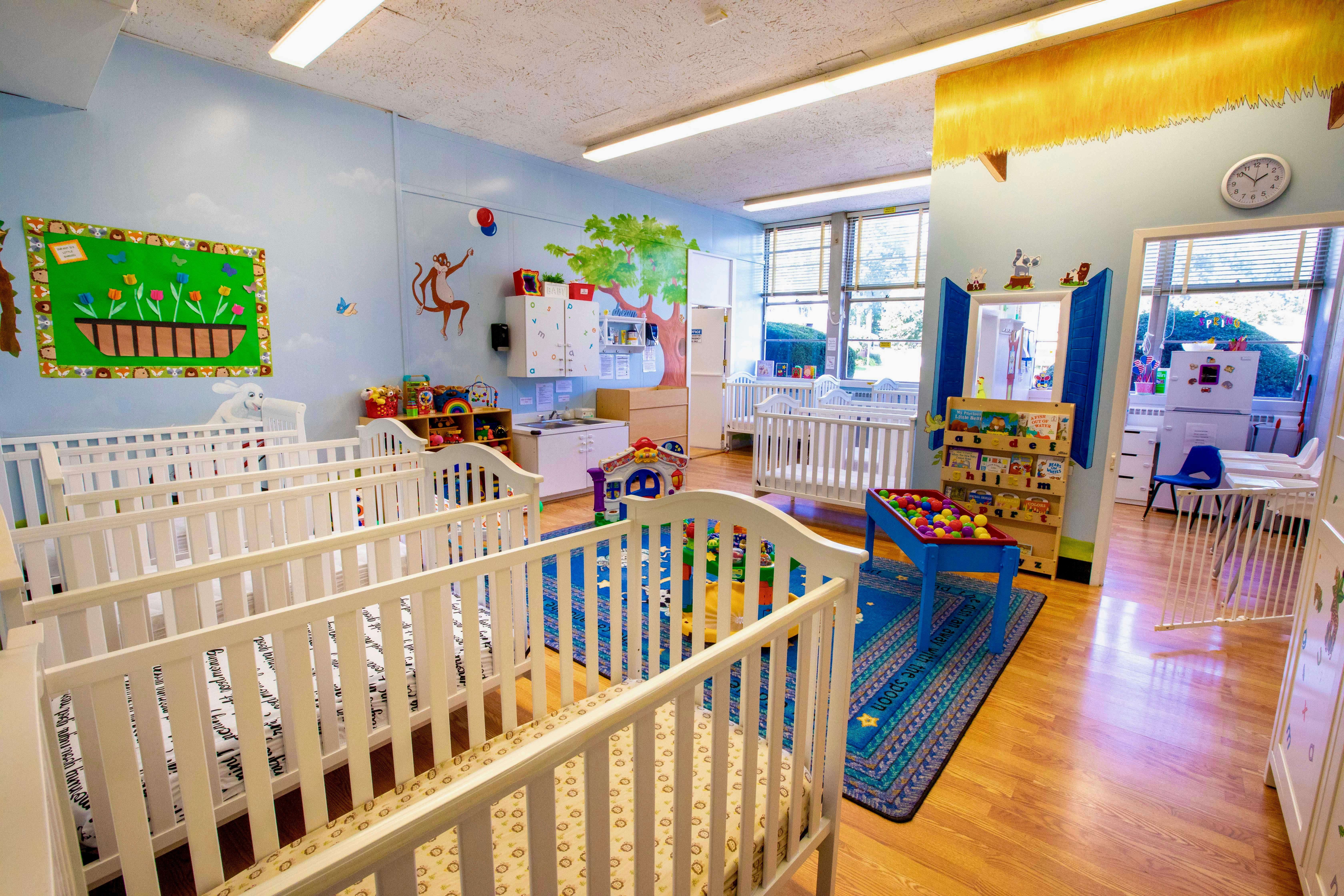 Nursery room with multiple white cribs and colorful decorations