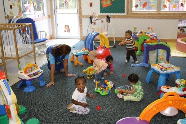 Adult and multiple children playing with toys in a room