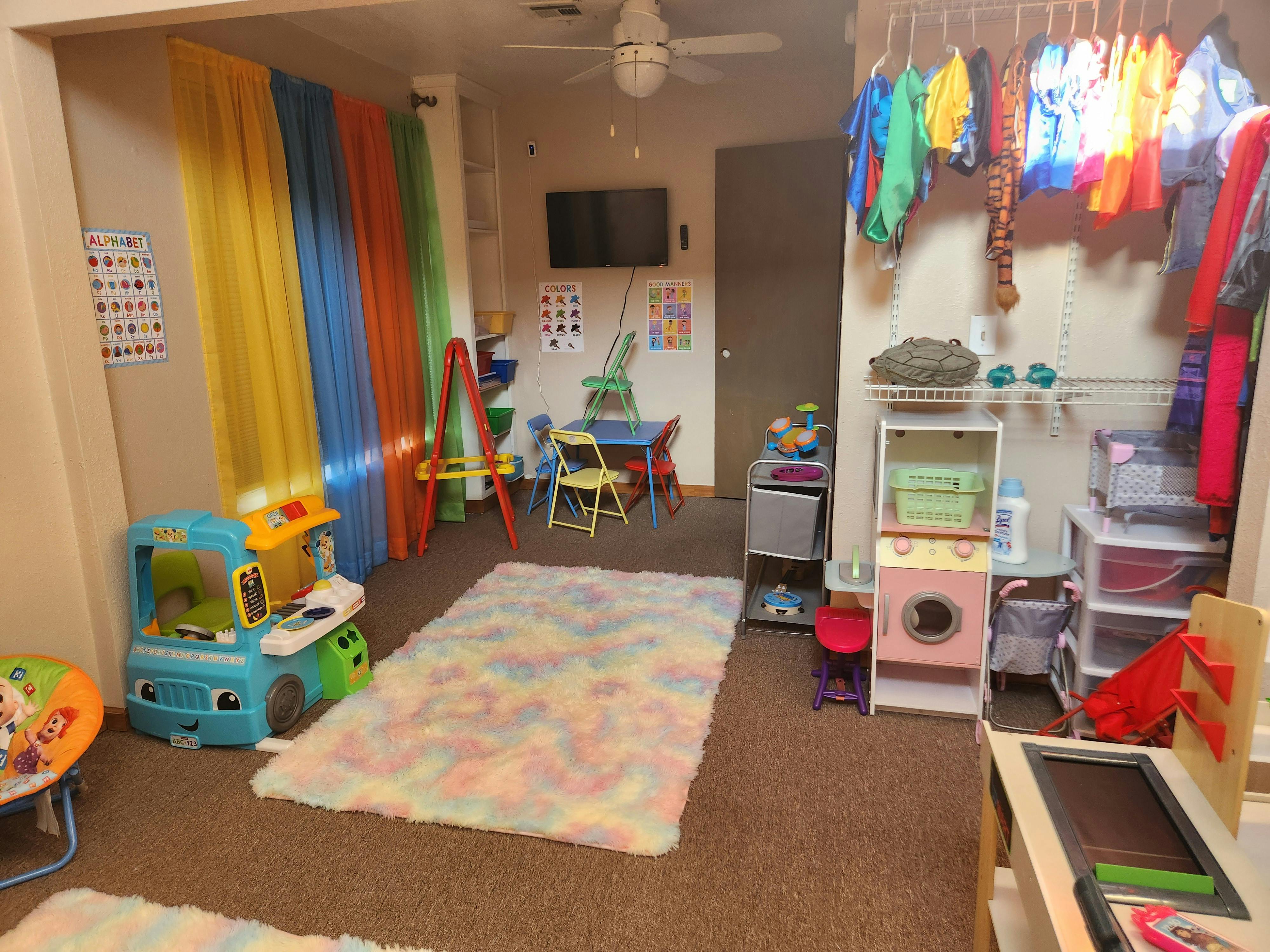 Playroom with colorful curtains, toys, and a rug