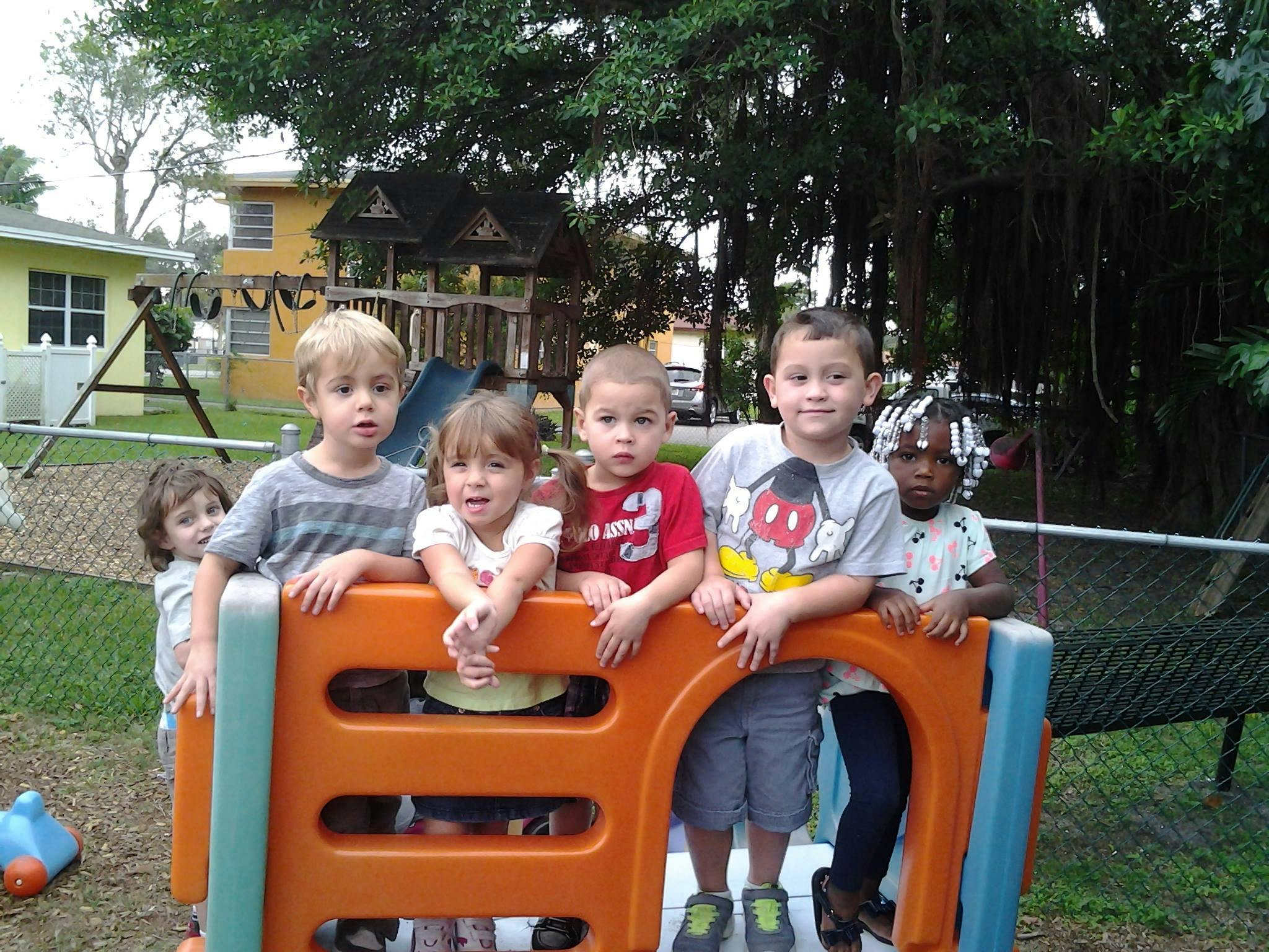 Group of children standing behind a play structure