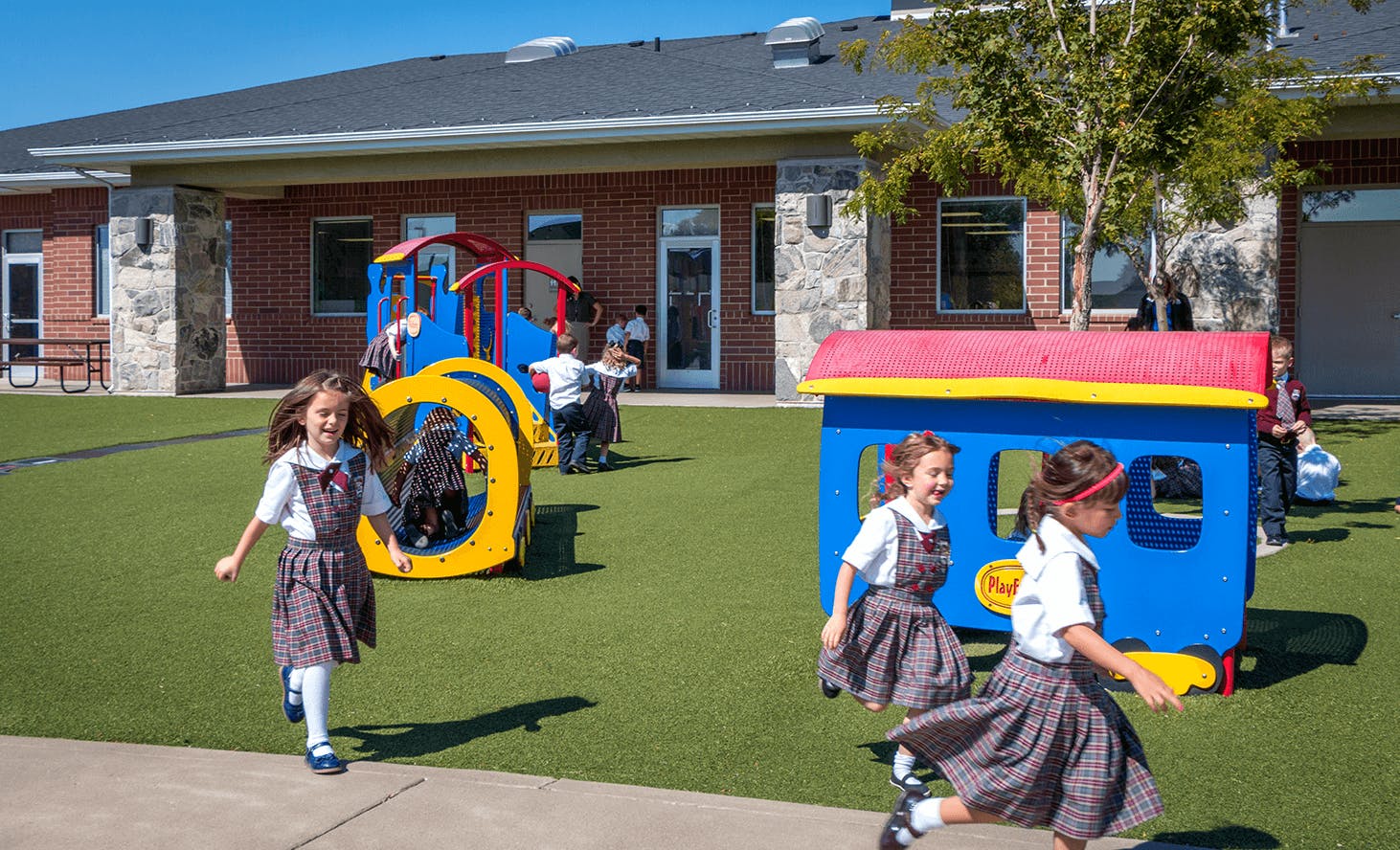 Children running on a playground with play structures