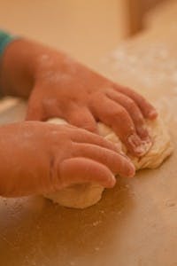 Child's hands kneading dough