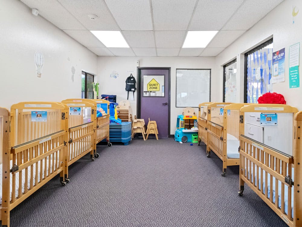 Rows of wooden cribs in a daycare or nursery room