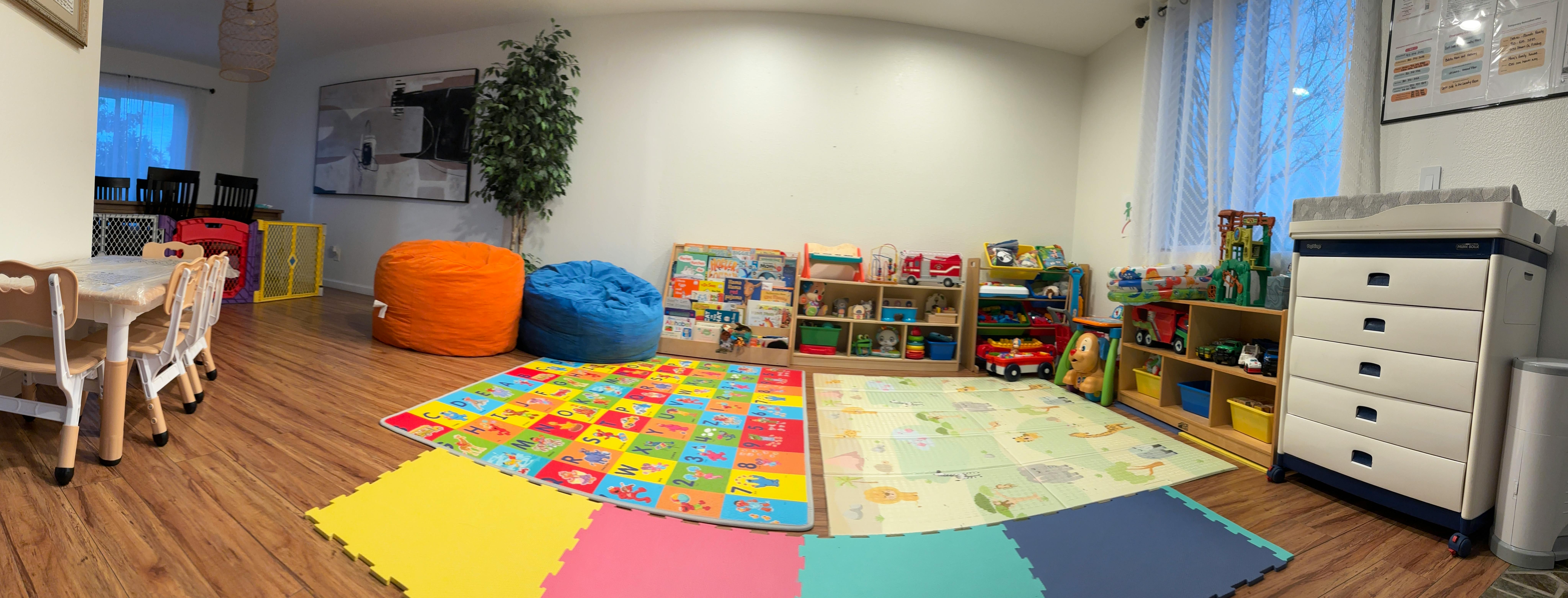 Playroom with colorful mats, beanbags, and shelves of toys