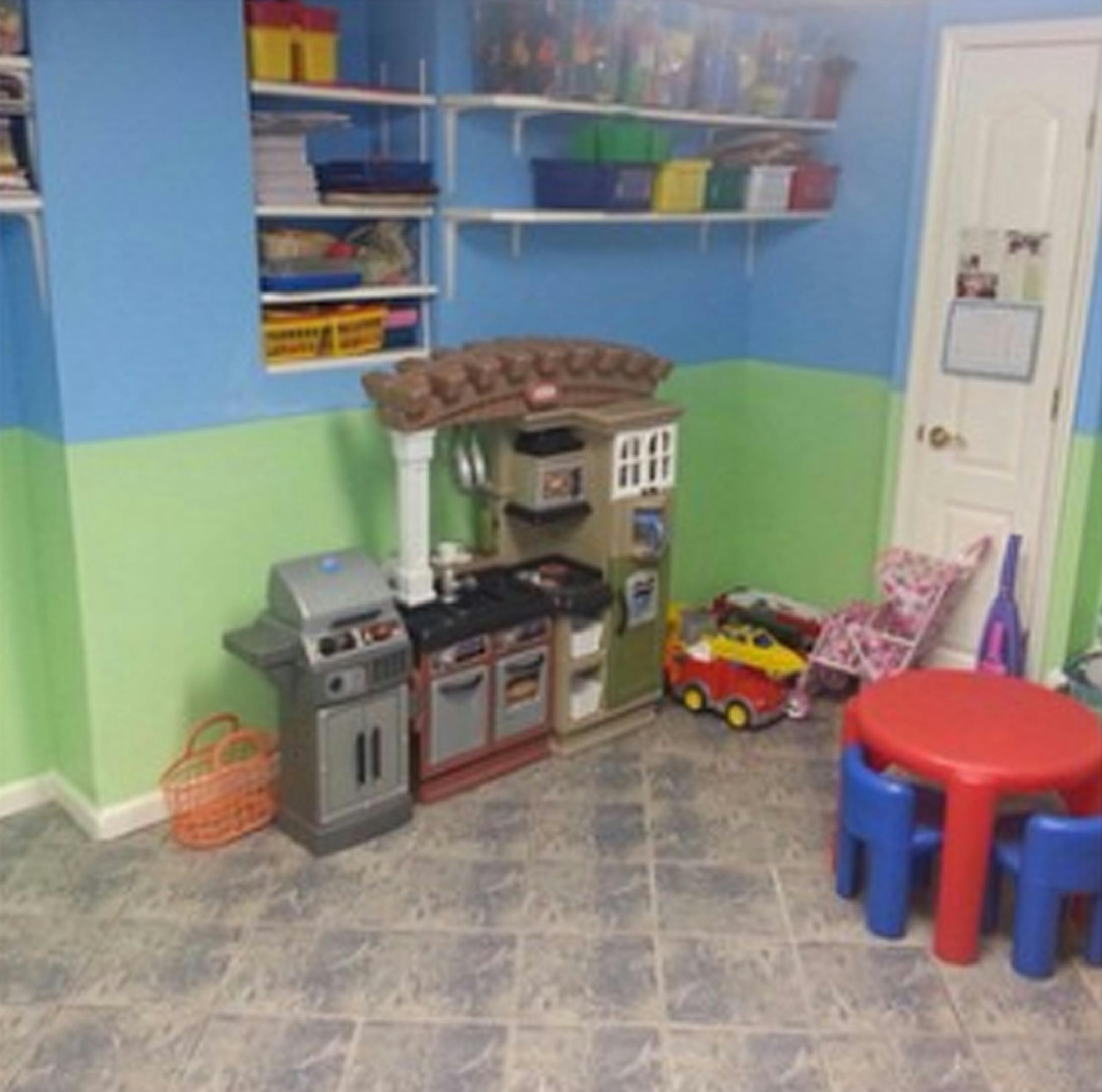 Playroom with toy kitchen, grill, red table, and blue chairs