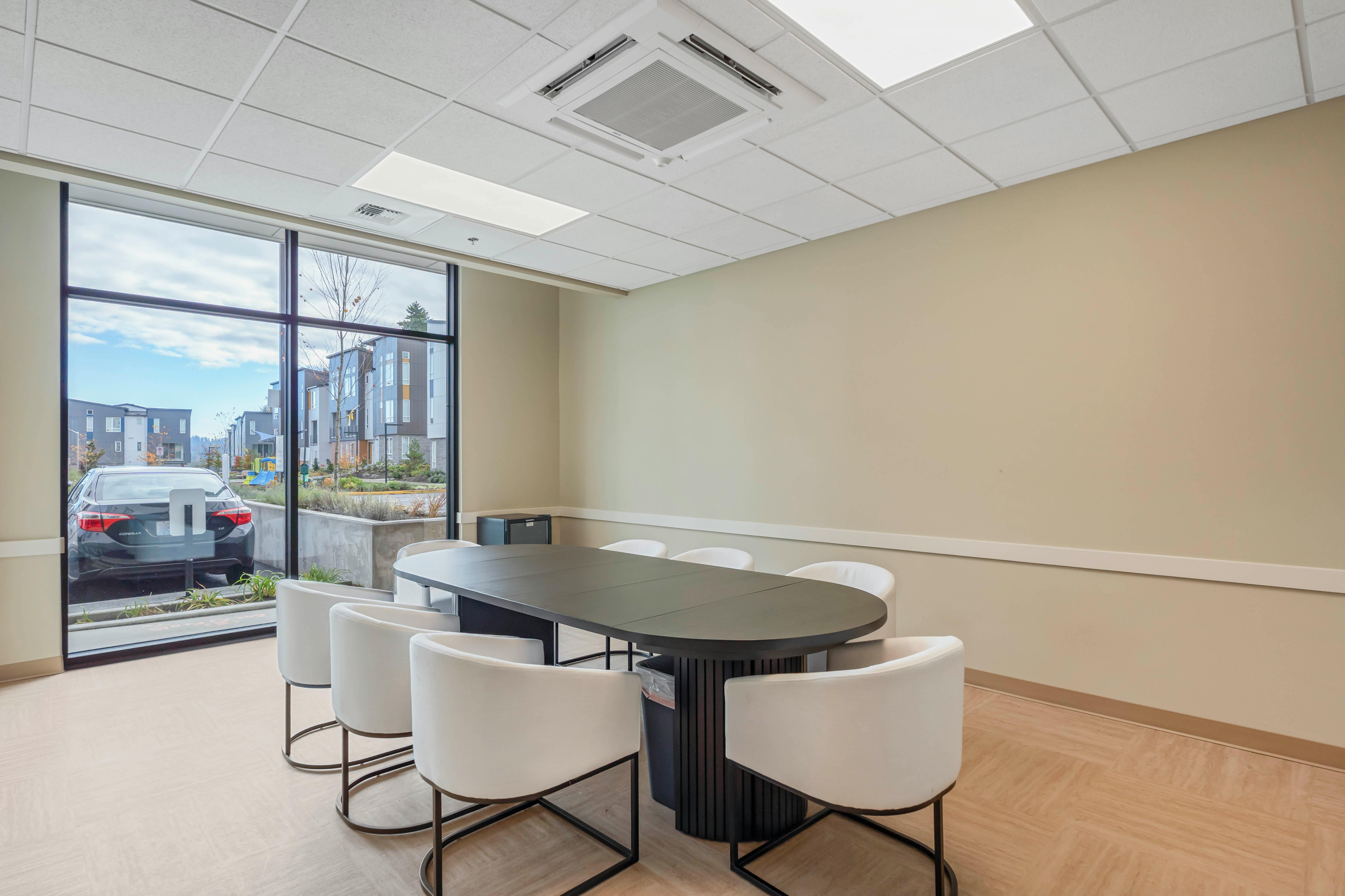 empty conference room with a black table and white chairs