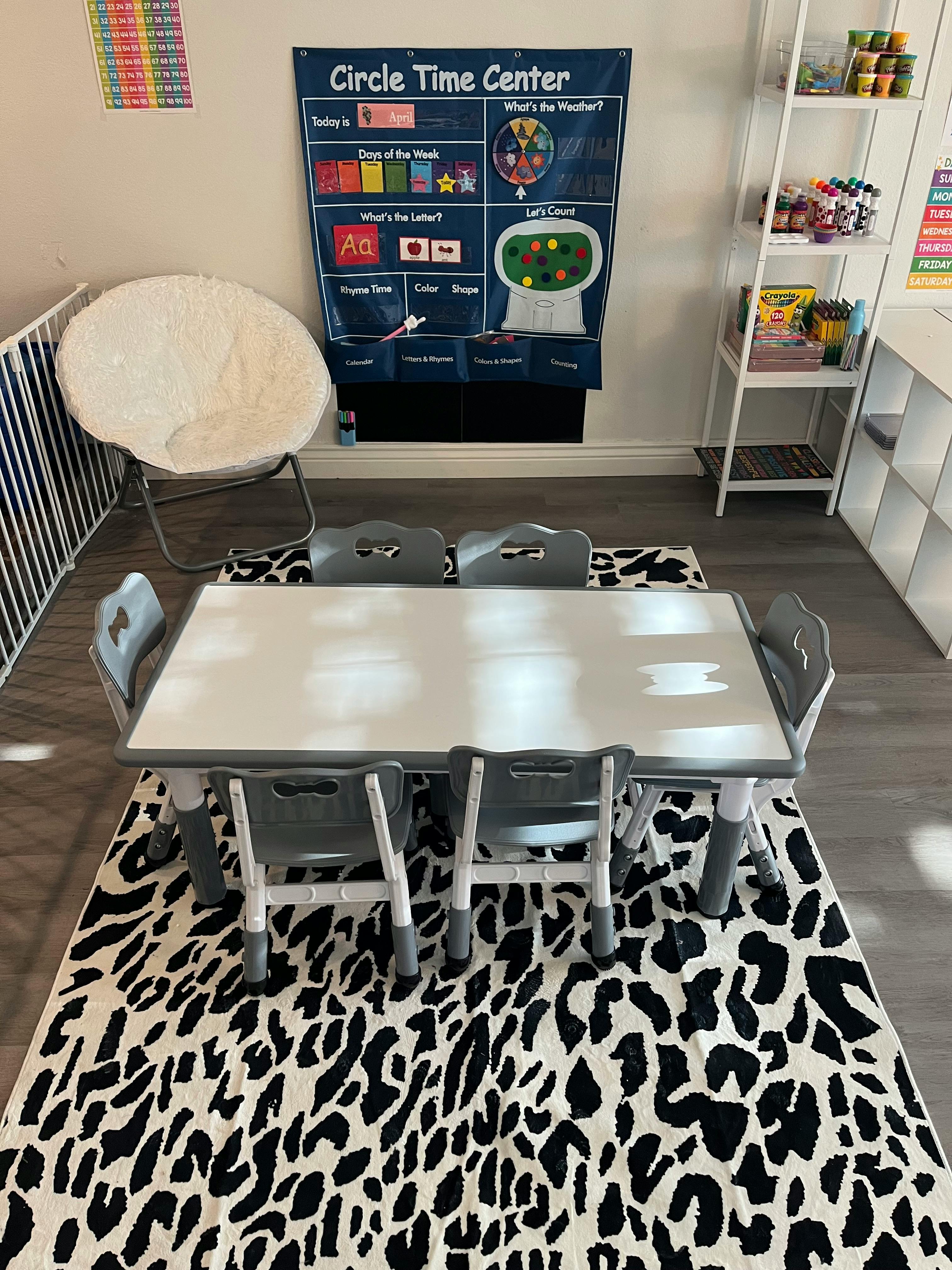 Children's table and chairs on a patterned rug in a classroom