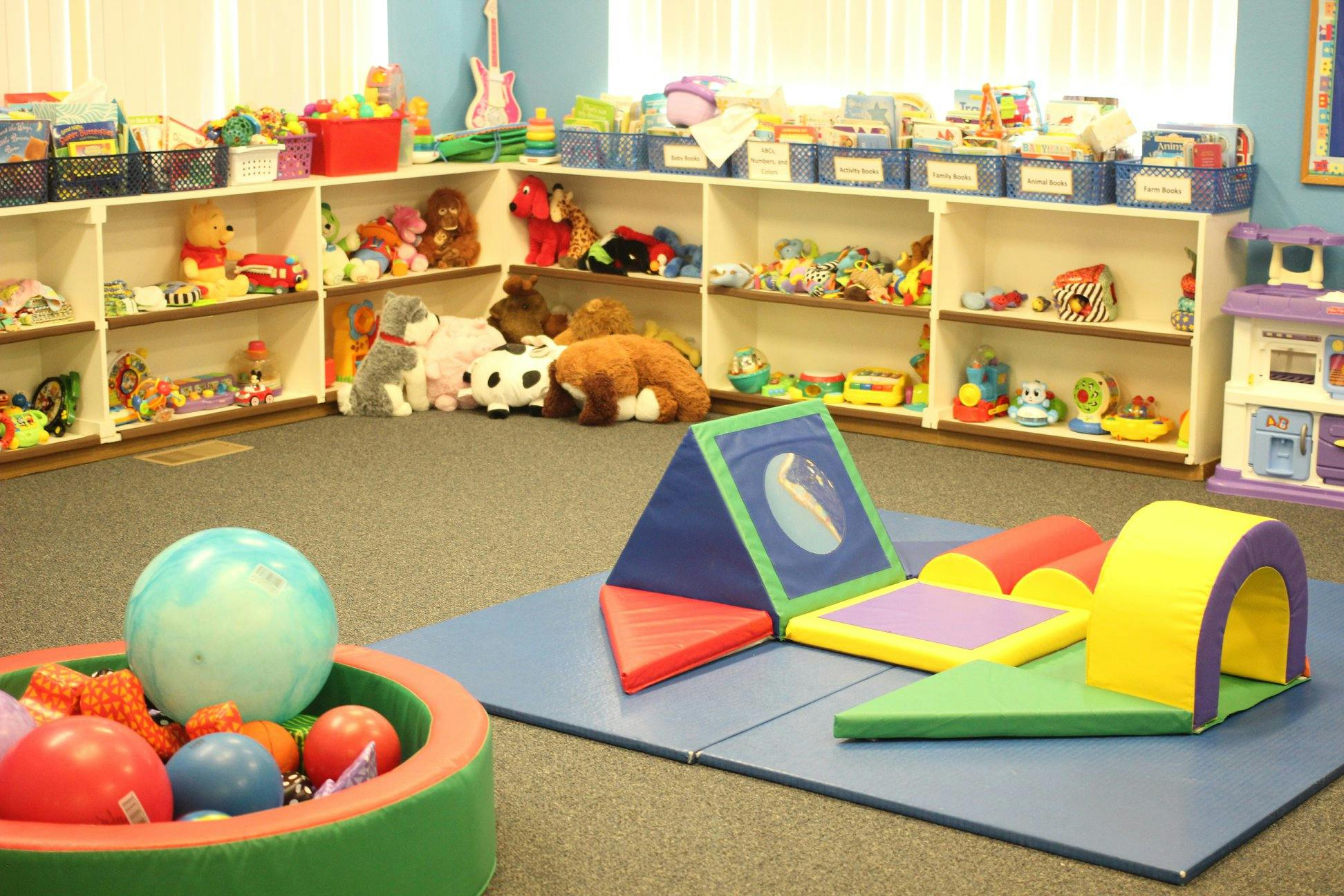 Playroom with soft play equipment and shelves of toys