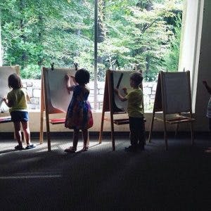 Children drawing on easels