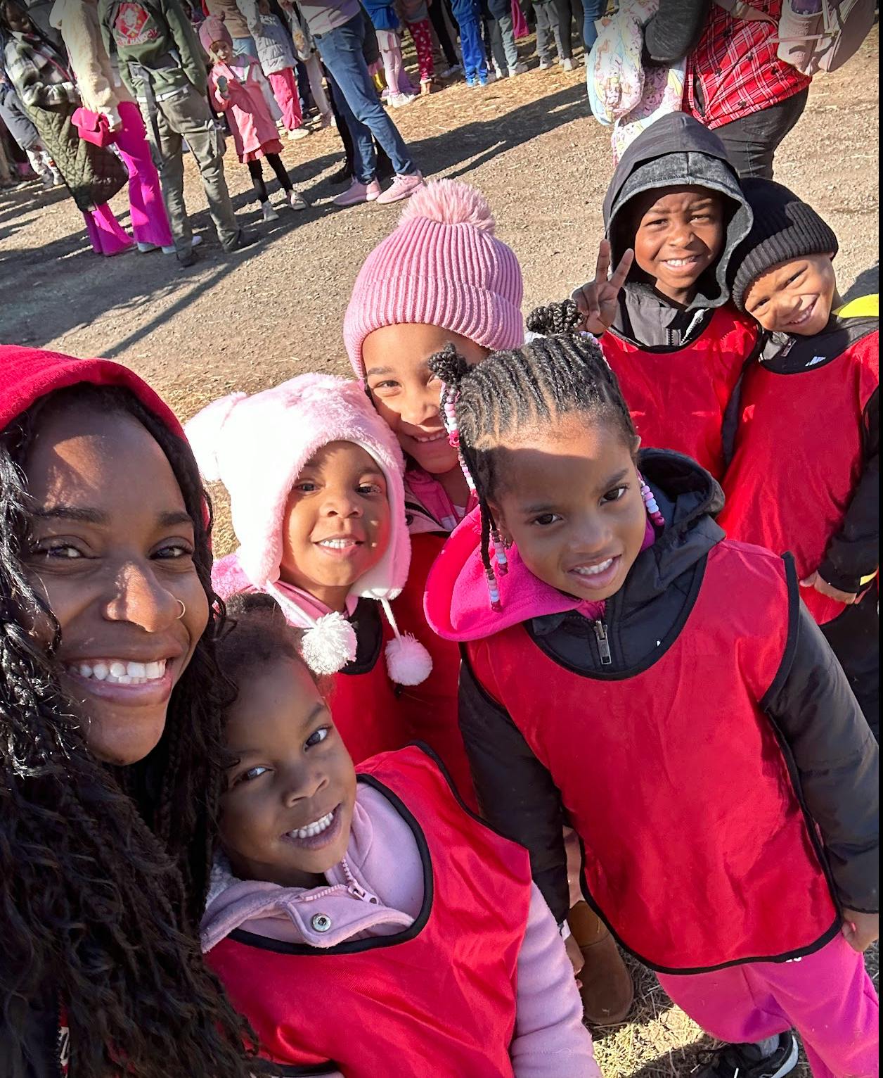 Group of children and an adult posing for a selfie outdoors