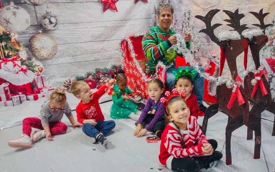 Person in a sleigh with several children sitting on the floor
