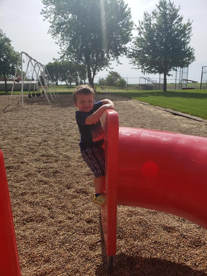 Child climbing on a red playground structure