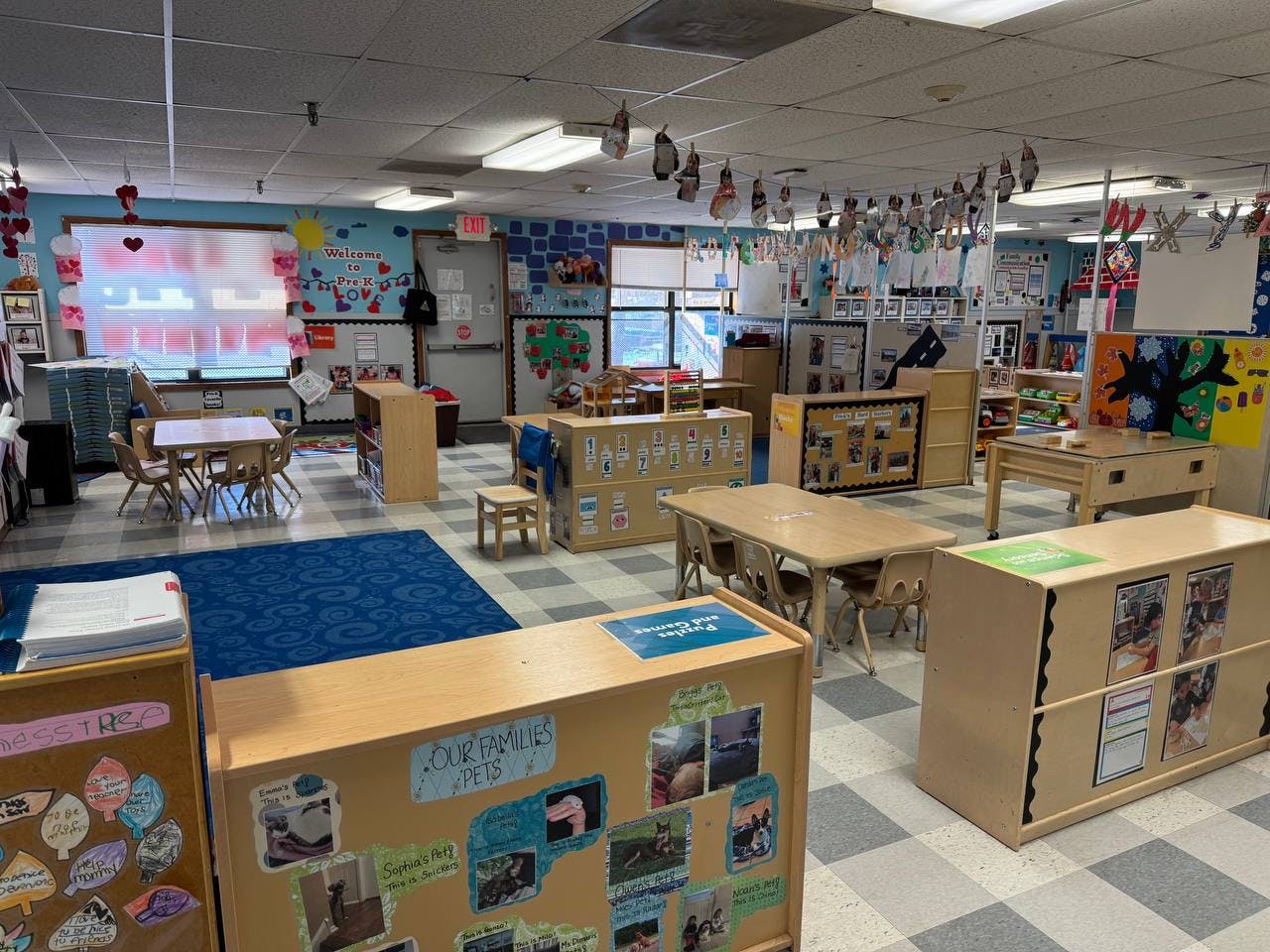 Empty classroom with small tables and chairs, and wall decorations