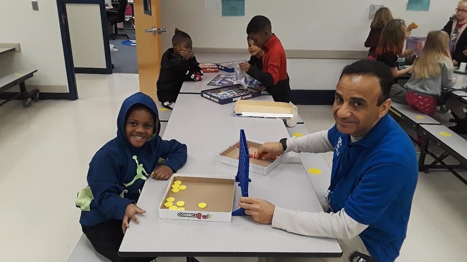 Adult and child playing a board game at a table